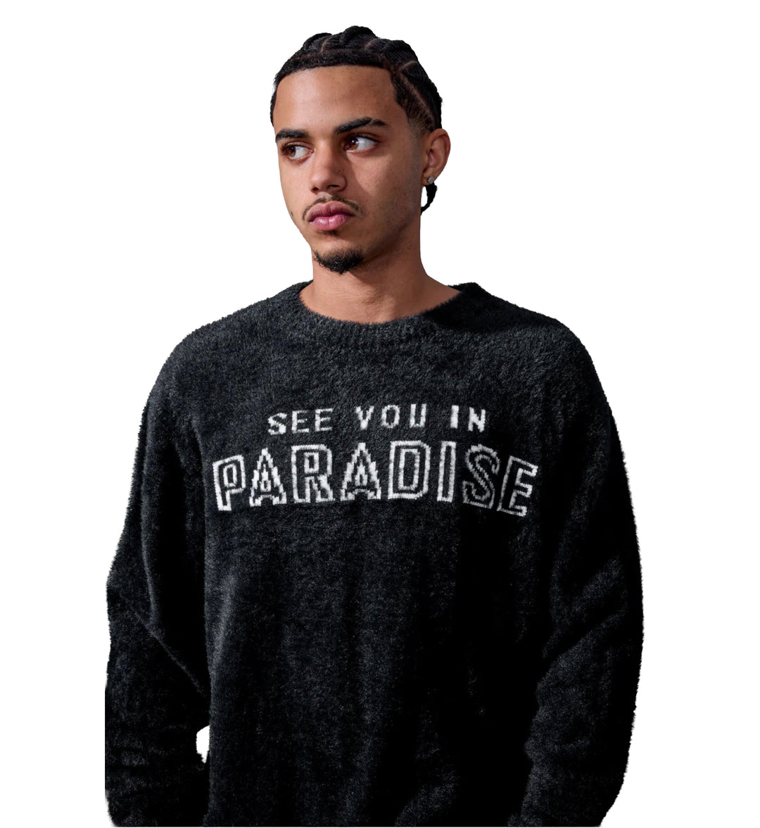 Man wearing a Plush Crewneck Sweater — Black with 'See You in Paradise' text on a white background
