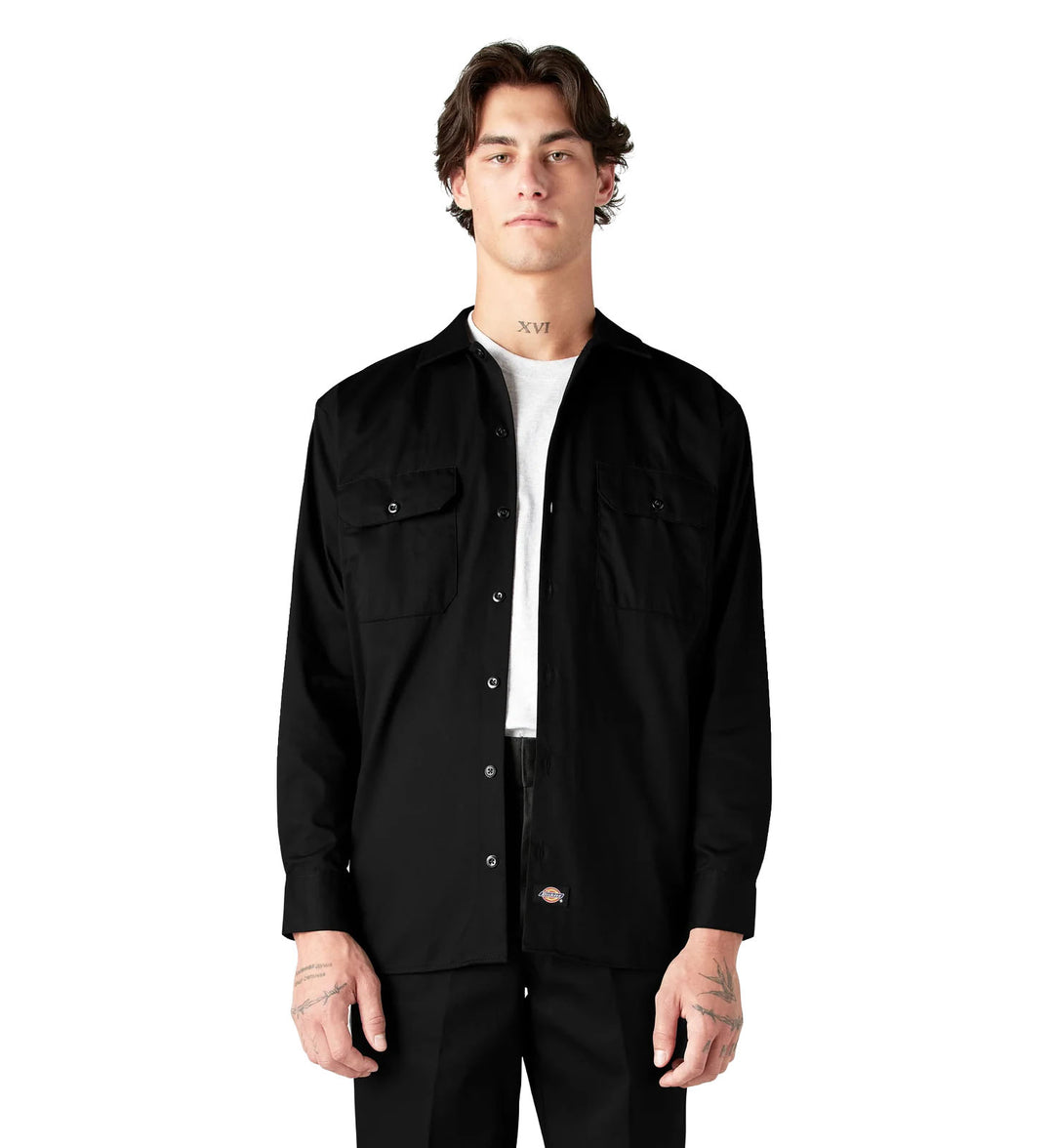 Man wearing a black Dickies Long Sleeve Work Shirt over a white shirt on a white background