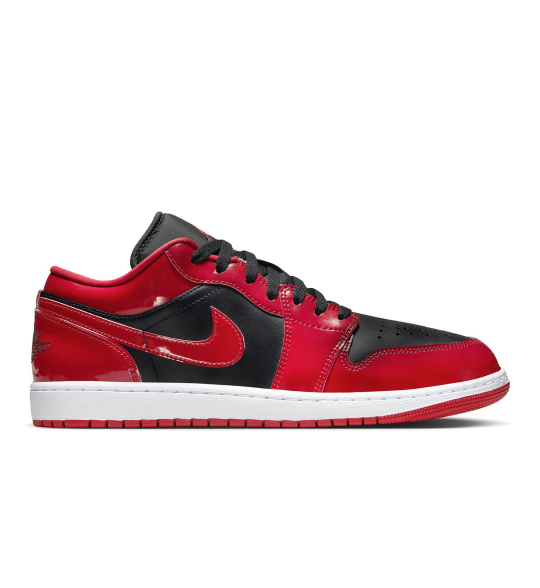 A red, black, and white low-top Nike Air Jordan 1 Low SE sneaker with black laces on a white background.