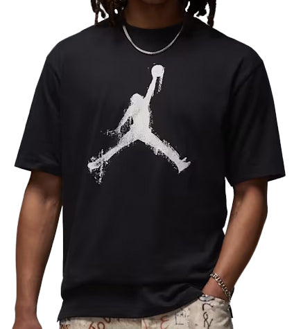 Person wearing a black Jordan Brooklyn t-shirt with a white logo on a plain background