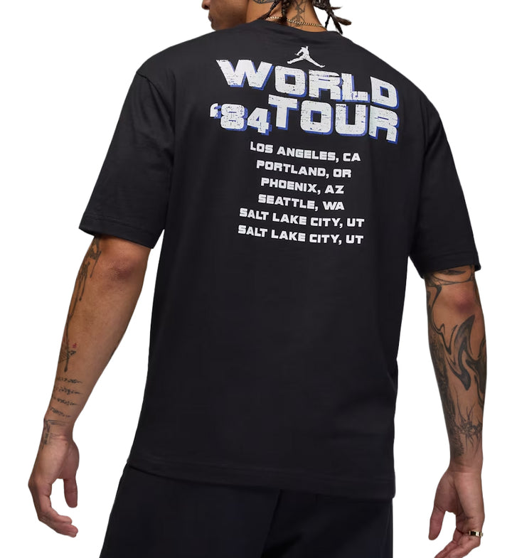 Black Jordan World Tour t-shirt with 'World Tour '84' text on the back, worn by a person.