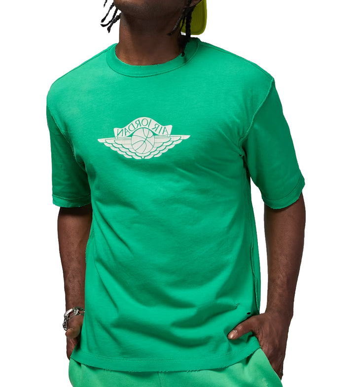 Person wearing a green Jordan Rare Air T-shirt with a logo on a white background