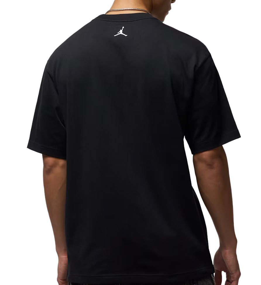 Black Jordan Photo t-shirt with a logo on the back worn by a person, on a white background