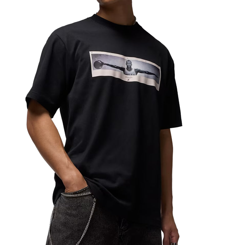 Person wearing a black Jordan Photo t-shirt with a graphic design on a white background