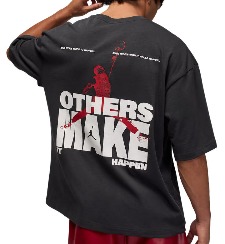 Black Jordan Oversized Reissue t-shirt with red and white graphic design on the back, worn by a person.