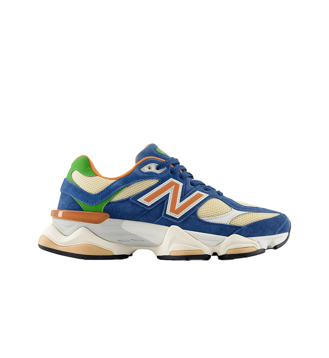Blue sneaker with green, orange, and beige accents on a white background